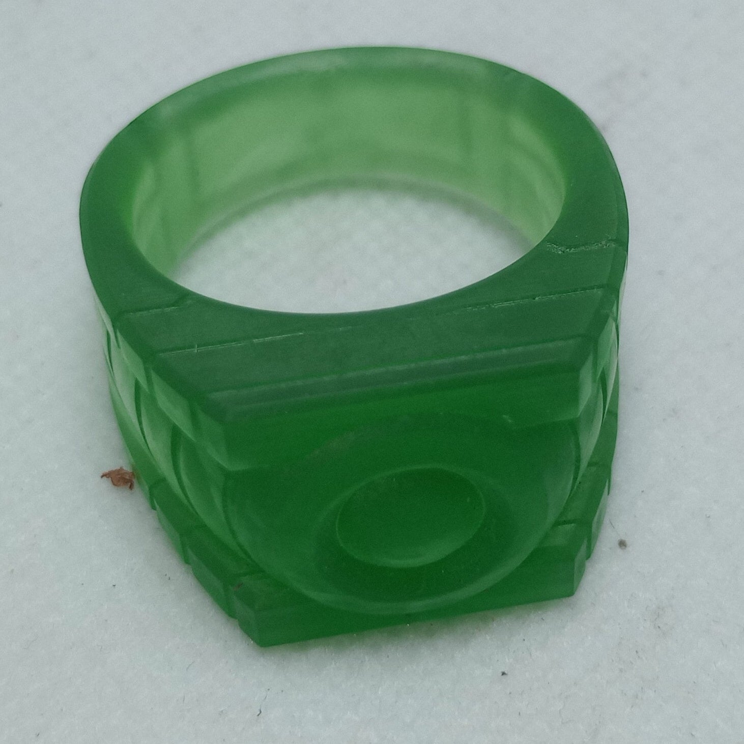 Green plastic ring on a textured white surface